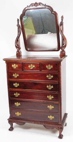 A mahogany mirror back dressing chest, of three short and four long cockbeaded drawers flanked by quarter columns, the upper section with mirror set with scroll stiles with floral patera, the whole raised on compressed ball and claw feet, 199cm H, 98cm W,