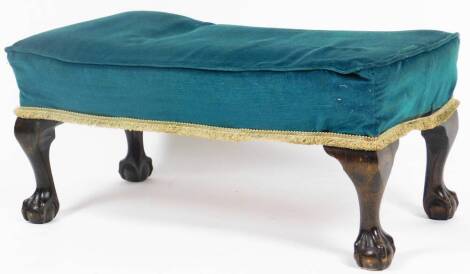 An early 20thC oak stained footstool, with overstuffed top, on cabriole ball and claw feet, 39cm H, 83cm W, 45cm D.