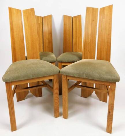 A set of four light wood dining chairs, with sloping two sectional backs and overstuffed seats in light coloured material and block front legs, 105cm H. (4)