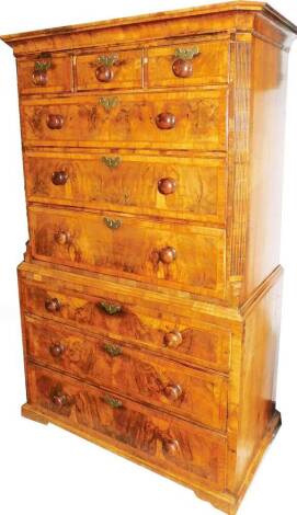 An early 18thC walnut tallboy or chest on chest, with moulded cornice raised above an arrangement of three short and six long drawers, the top section flanked by reeded columns, on compressed bracket feet, 170cm H, 101cm W, 56cm D.