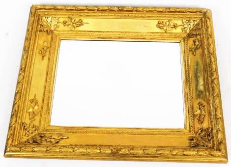 A late 19thC gilt wood mirror, of rectangular form, with moulded bellflower outline, plain glass, inner moulded frame and leaf spandrels, 87cm H, 76cm W, 14cm D.