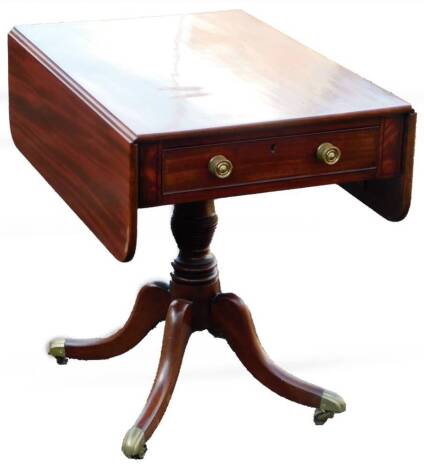 An early 19thC mahogany Pembroke table, the rounded leaf top raised above a real and dummy drawer, on a turned stem terminating in quadruple sabre legs with brass caps and castors, when closed 67cm H, 65cm W, 50cm D.