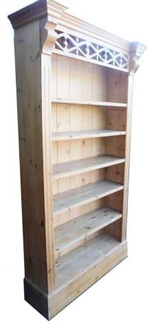 A 20thC reclaimed pine open bookcase, with a heavily carved frieze, raised above removable shelves, with a fixed breakfront cornice, on a plain base, 112cm W.