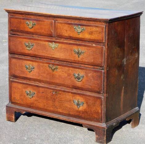 A George III oak chest, of two short and three long drawers, with plate back swan neck handles, raised on ogee bracket feet, 91cm H, 101cm W, 53cm D.