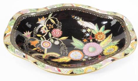 A 20thC Carlton ware dish, decorated with flowers on a black ground with a polychrome floral border, predominately in green, silver and pink, marked beneath, 27cm W.