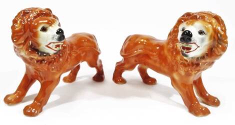 A pair of late 19thC Staffordshire pottery lion figures, in prowling pose, predominately in orange with black and red highlights, unmarked, 29cm H. (2)