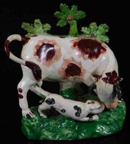 An early 19thC Staffordshire pottery bull baiting figure group, with a bull and dog, on a naturalistic setting, predominately in green, brown and black, unmarked, 16cm H.