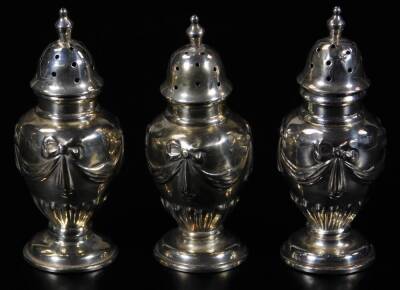 A set of three George V silver pepper pots, each with domed lids, shouldered circular bodies, inverted stems and circular feet, Birmingham 1912, 7cm H, 1½oz. (3)