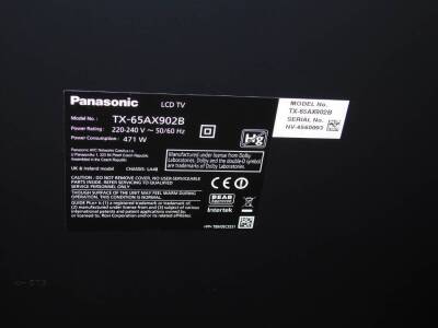 A Panasonic TX-65AX902B LCD 65inch colour television, on stand, in silver and black trim with wire and remote control. (LED Display broken once turned on) - 2