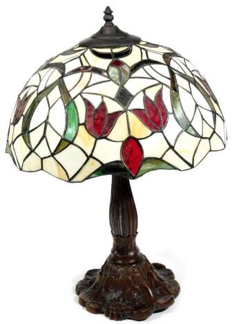 A Tiffany style lamp, with floral shade with lead type inserts, set with red flowers with green leaves, on a turned stem and floral foot, with electrical fitting, 66cm H.