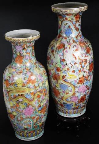 A pair of Chinese semi-porcelain vases, of large proportion, each shouldered body decorated with five clawed dragons, on a floral ground predominately in orange, green and blue with gilt highlights, seal marks beneath, 61cm H, on wooden plinth bases. (2)