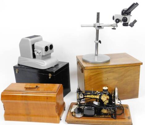 A rectangular box containing a Russian microscope with lens and other accessories, an M5C-2 Russian lens stand, 45cm H, various other optical equipment, a cased sewing machine and a cased projector. (3)