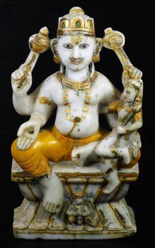 A carved Indian alabaster figure of a god, probably Vishnu, in seated pose aside further figure on inverted plinth base, picked out in colours, predominately in gilt, green and yellow, 34cm H.