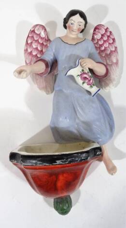 A 19thC pottery figure of an angel, holding jug above font, polychrome decorated in pink, blue, red and black, unmarked, 20cm H.