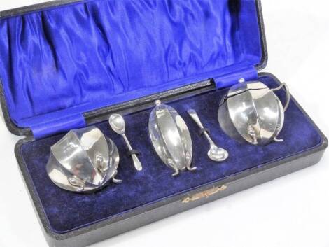 A George V silver cruet set, comprising pepper pot, mustard pot and open salt, 5cm H, with two associated spoons, Birmingham 1915, cased, 3½oz all in.