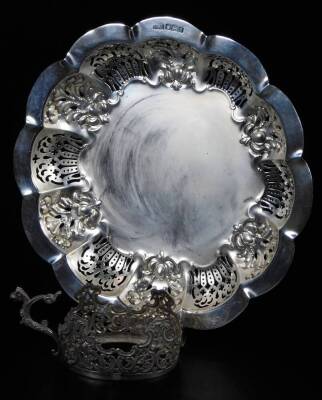 An Edwardian silver dish, of fancy pierced form, with floral outline and plain centre, Sheffield 1906, 22cm W and silver Tody cup holder, 10oz all in. (2)