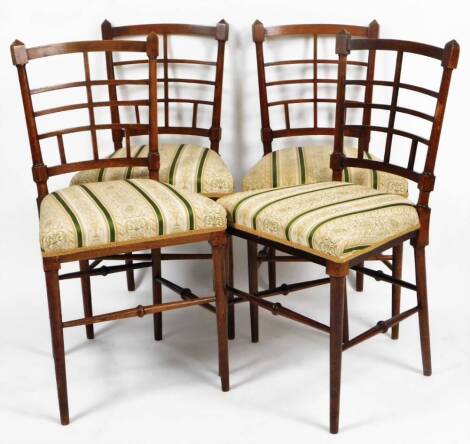 A set of four late 19thC mahogany aesthetic period salon chairs, each with lattice backs, overstuffed seats in floral striped material, on tapering turned legs, 84cm H. (4)