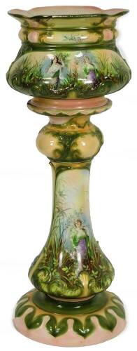 An early 20thC continental pottery jardiniere on stand, overall decorated with raised scrolls and transfer printed with figures in a garden setting with a repeat flowerhead banding, chrome decorated predominantly in green and pink, numbered beneath, 114cm