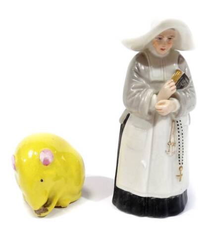 A late 19thC Royal Worcester nun candle snuffer, modelled in standing pose, 1892, 10cm H and a Royal Worcester miniature figure group of a mouse, in canary yellow with pink ears eating a nut. (2)