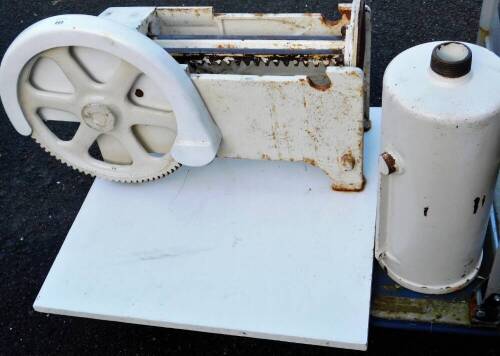 An industrial meat slicer, painted white, on wooden plinth base, 40cm H.