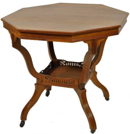 An early 20thC walnut stained window table, the octagonal top raised on inverted scroll legs, joined by a galleried undertier, 70cm H, 76cm w, 76cm D.