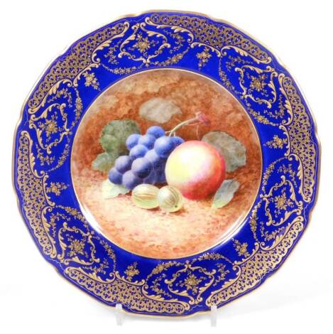 A Royal Doulton handpainted plate, by F Reynel, centrally painted with gooseberries, apples and grapes, with a royal blue border, gilt highlighted with scrolls and garlands, signed, with printed marks beneath, 27cm W.