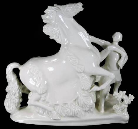 A Russian Verbilki white porcelain figure group of a rearing horse and master, on a floral ground, red stamp mark beneath, 27cm H.