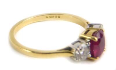 An 18ct gold ruby and diamond three stone ring, central set with oval cut ruby approx 6.62mm x 5.80mm x 2.95mm depth, total estimated carat weight 1ct, in a gold four claw setting, flanked by two round brilliant cut diamonds, each measuring 4.10mm x 4.2mm - 2