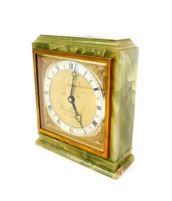 An Elliott green onyx cased mantel clock, square brass dial with cherubs head spandrels, silver chapter ring bearing Roman numerals for J R Ogden & Son Ltd, London & Harrogate, clockwork movement, the case of rectangular section, raised on a plinth base,