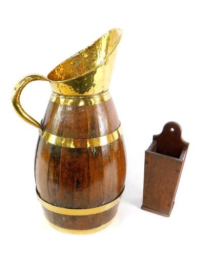 A coopered oak and brass bound ewer, with brass handle and spout, 62cm H, together with an oak wall hanging candle holder, 32.5cm H. (2)