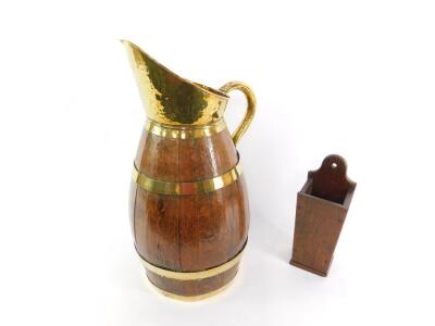 A coopered oak and brass bound ewer, with brass handle and spout, 62cm H, together with an oak wall hanging candle holder, 32.5cm H. (2) - 2