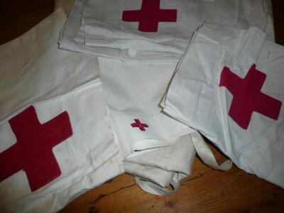 A collection of vintage Red Cross nurses aprons and head dress