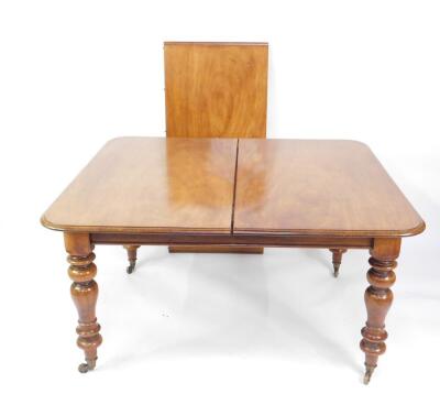 A Victorian mahogany wind out dining table, with moulded top, one additional leaf, raised on turned legs, brass capped on castors, 122cm W, 135cm L + 56cm leaf.