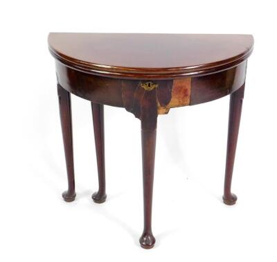 A George III mahogany demi lune tea table, with a fold over top, raised on turned legs and pad feet, 75cm W.