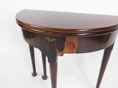 A George III mahogany demi lune tea table, with a fold over top, raised on turned legs and pad feet, 75cm W. - 2