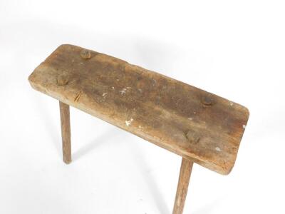 A 19thC rustic pine stool, the rectangular plank top raised on four angled turned legs, 51cm H, 82cm W. - 2