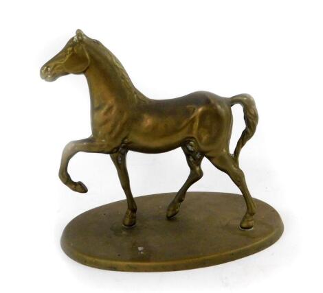 A brass figure modelled as a prancing horse, raised on an oval base, 16.5cm W.