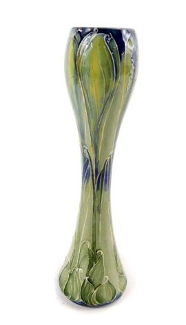 An early 20thC Moorcroft pottery bud vase, for Liberty & Co, of waisted form, decorated with stylised leaves, printed and painted marks, 21cm H.