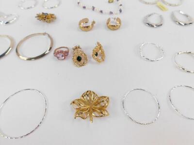 Costume jewellery, comprising eight silver hoop earrings, a faux pearl bracelet, imitation gold hoop earrings, pink stone set dress ring, elaborate paste stone floral earrings and two brooches. (qty) - 2