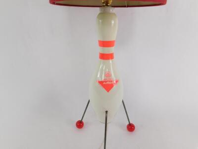 An Atomic style table lamp, the body formed as a ten pin bowl Amflite II, raised on three metal rod legs, with ball feet, and red banded cylindrical shade, 69cm H. - 2