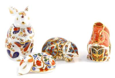 A Royal Crown Derby paperweight modelled as a red squirrel, another of a sleeping cat, both boxed, together with a sleeping piglet and a continental porcelain figure modelled as a seated rabbit. (4)