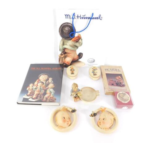 A pair of Hummel porcelain oval boxes and covers, Scamp and Pixie, a pair of circular baby's head and bee wall plaques, an ash tray, musical box, Hummel bag and two collector's books. (9)