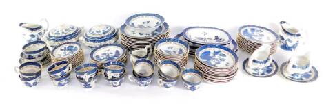 A Booths pottery dinner and tea service decorated in the Real Olde Willow pattern, comprising three meat platters, pair of vegetable tureens and covers, two oval dishes, pair of sauce boats on stands, twelve dinner, dessert and sixteen side plates, twelve