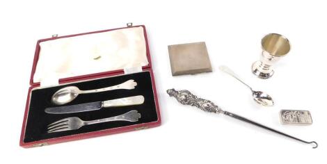 A silver trefid spoon and fork set, cased, Sheffield 1959, George VI powder compact, Birmingham 1947, George V egg cup and spoon, initialled engraved, Birmingham 1914, Edward VII silver handled button hook, Birmingham 1901, and a silver ingot commemoratin