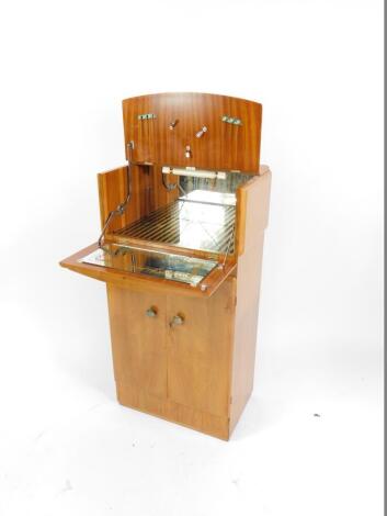 An Art Deco walnut and burr yew wood cocktail cabinet, the top opening to reveal a glass back fitted interior, over two doors enclosing a shelf and bottle stand, raised on a plinth base, 113cm H, 59cm W, 40.5cm D.