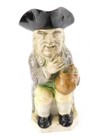 A late 18thC Ralph Wood pottery toby jug, modelled traditionally seated smoking a pipe and holding an ale jug, raised on a canted square base, 24cm H.