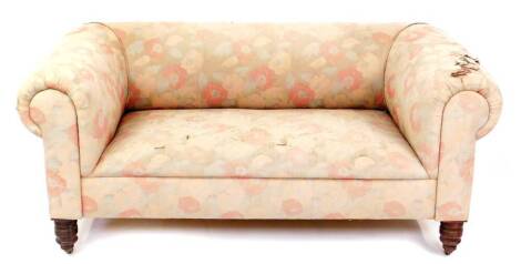 A Victorian mahogany Chesterfield sofa, with pink floral upholstery, raised on turned legs, brass capped on castors, 163cm W.