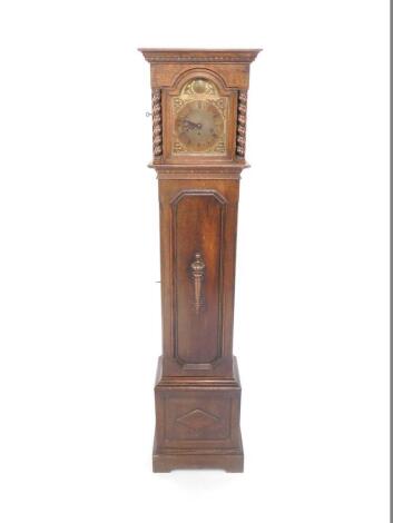 An early 20thC oak cased grandmother clock, brass Tempus Fugit break arch dial with floral spandrels, chapter ring bearing Roman numerals, eight day movement with Westminster chimes, the case with outswept pediment over a hood with spiral fluted columns, 