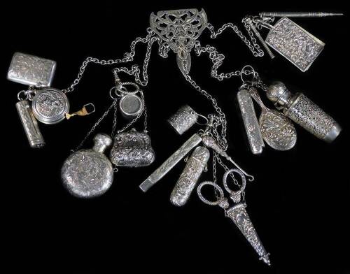 A late Victorian silver chatelaine, with heavy links and clips, set with various Edwardian and other pieces, chased pen knife, continental tape measure, bucket, perfume bottle, pencil, scribe set, vesta case, miniature purse, notebook, 6cm W, etc. Birming