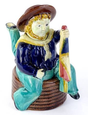 A Majolica Isle of Man teapot and cover, possibly William Brownfield and Son, modelled in the form of a three legged sailor, seated on a coil of rope, etc., 21cm H.